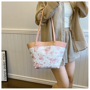 Detail einer Tasche mit rosa Schmetterlingsdruck und Lederriemen für Damen