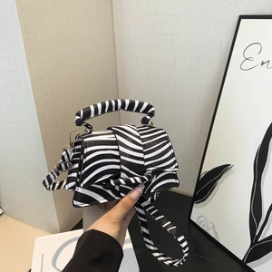 Modern zebra print mini handbag with structured top handle and stylish metal strap hooks