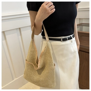 Détail du sac bandoulière tissé avec texture résille et finitions cuir sur modèle