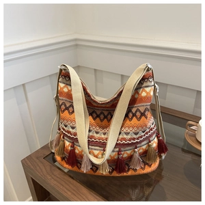 Detailed view of bohemian woven tote bag with colorful fringe and geometric patterns