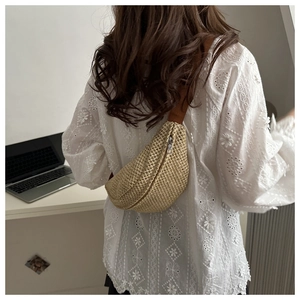 Détail d'un mini sac banane tissé en paille beige avec fermeture éclair argentée
