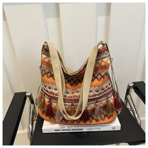 Detail of ethnic woven tote bag with orange geometric patterns and long fringes