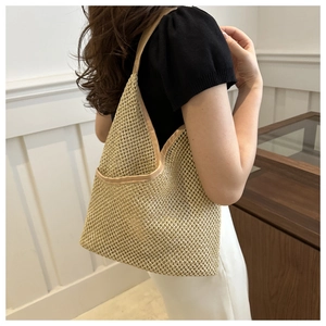 Détail du sac cabas en paille tissée beige avec texture en maille et bords renforcés