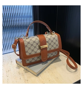 Détails du sac bandoulière vintage avec monogramme, fermoir métallique et poignée en cuir