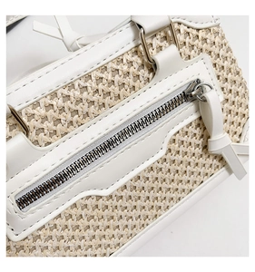 Détail macro de la texture en paille avec bordure en cuir blanc et poche zippée argentée