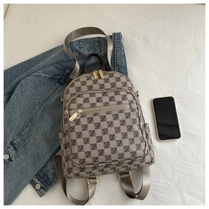 Detail of checkered casual backpack showing beige pattern and golden metal zippers