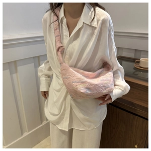Gros plan détaillé d'un sac hobo en nylon matelassé rose avec broderies géométriques colorées