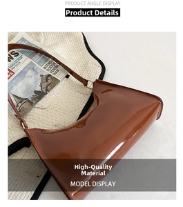 Detail view of glossy dark brown patent leather shoulder bag with gold hardware
