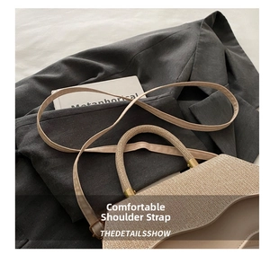 Detail of woven straw handbag with thin leather strap and metallic gold buckle accents
