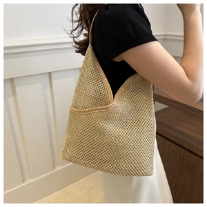 Détail du sac cabas en paille tressée avec maille ajourée et bordure en cuir brun