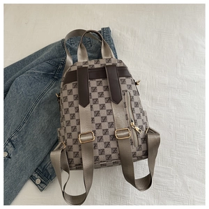 Detailed top view of plaid backpack with geometric Z-pattern next to denim jacket