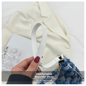 Détail du sac en denim à damier bleu avec bandoulière en cuir blanc et boucle dorée