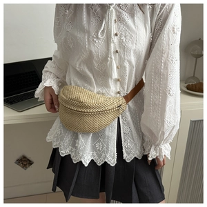 Mini sac banane en paille tressée avec bandoulière en cuir marron porté par un mannequin