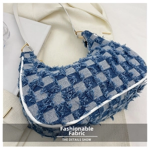 Gros plan sur le tissu denim à damier bleu et blanc avec détails frangés du sac
