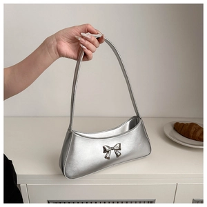Detail of silver metallic handbag with bow buckle and slim shoulder strap