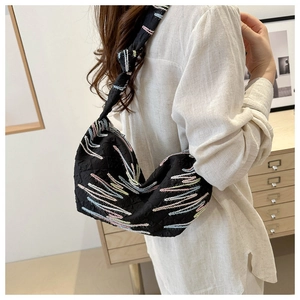 Gros plan du sac hobo noir matelassé avec broderie de lignes colorées