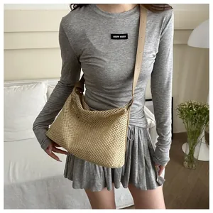 Détail du sac cabas en paille tissé main avec bandoulière en simili cuir beige sur mannequin