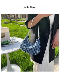 Modèle portant un sac hobo en denim à carreaux bleus et blancs avec bords effilochés stylés