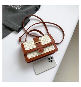Détail d'un sac bandoulière vintage en toile beige avec cuir marron et fermoir doré