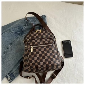 Detail view of plaid monogram backpack with golden zippers and fabric shoulder straps