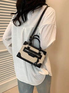 Mini sac bandoulière tissé rétro avec finitions en cuir noir porté par un mannequin