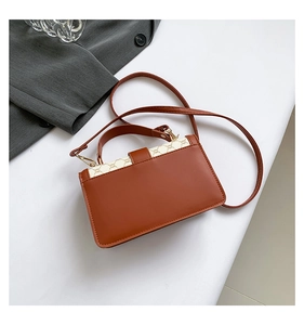 Détail du petit sac à bandoulière vintage en cuir marron avec toile à motif classique