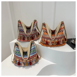 Detail of colorful woven hobo tote bag with ethnic fringe and cotton fabric texture