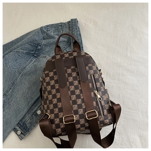 Macro view of checkered pattern fabric and rear hidden anti-theft zipper on travel backpack