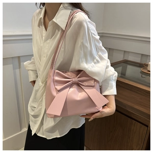 Vue détaillée du grand nœud rose sur un sac à bandoulière en similicuir élégant