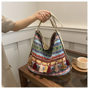 Close-up of bohemian knit tote bag with vibrant geometric patterns and colorful tassels