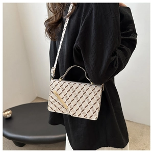 Detailed view of checkered crossbody bag with bear print on casual chic outfit