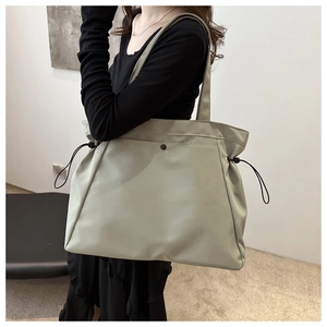 Detail view of large sage green tote bag with side drawstring and shoulder strap