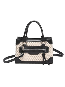 Mini sac bandoulière en paille avec bordures en cuir noir et pompon sur fond blanc