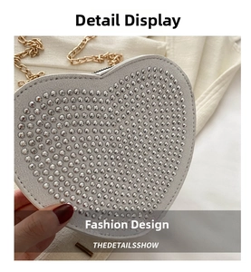 Detail shot of heart-shaped white handbag with silver rhinestones and gold chain