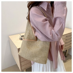 Détail du sac à bandoulière en paille tressé main avec texture beige et bordure