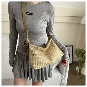 Détail du sac cabas en paille tissée à la main avec bandoulière en cuir marron