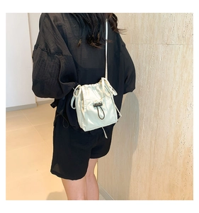 Detailed view of light green nylon drawstring bucket bag with black toggle closure