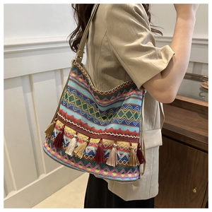 Detail of bohemian tote bag featuring colorful woven wave patterns and tassel accents