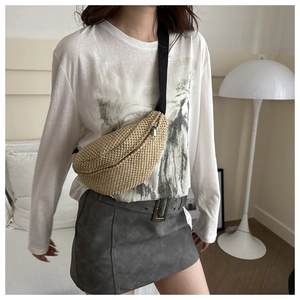 Détail du sac bandoulière en paille tressée beige avec sangle réglable sur le mannequin