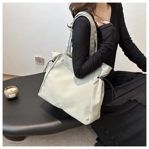 Detail of adjustable side drawstrings on large sage green nylon tote bag