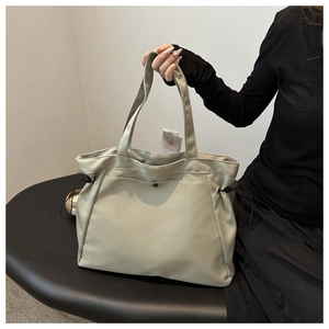 Close-up of light gray large capacity tote bag with adjustable side drawstring details