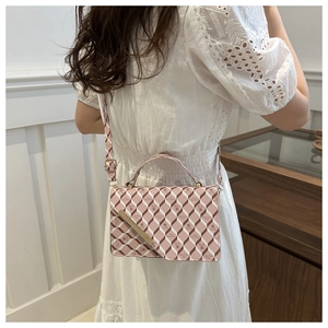 Detail of pink plaid shoulder bag with cartoon bear prints and metallic accent trim