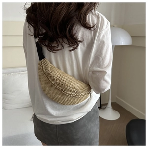 Détail d'un sac banane pour femme en paille tressée avec sangle noire réglable et fermeture