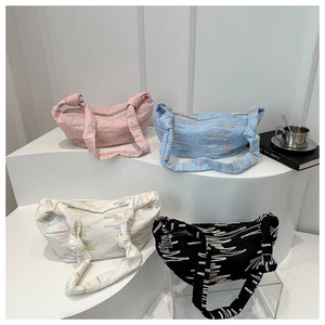 Chic quilted crescent bags with embroidery in four colors on a modern display stand