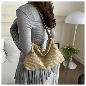 Beige woven tote bag with brown leather straps styled in a modern home interior