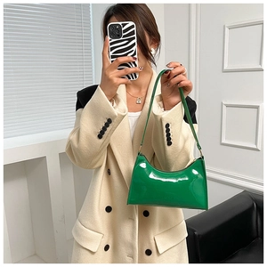 Glossy vibrant green patent leather shoulder bag with sleek handle and gold-tone hardware