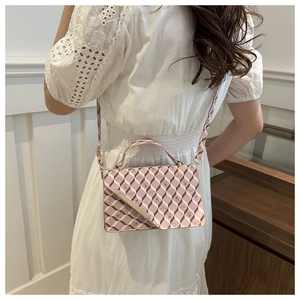 Detail of pink and brown argyle shoulder bag with cute bear prints and gold bar accent