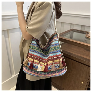 Close-up of colorful ethnic woven shoulder bag with geometric patterns and fringe tassels