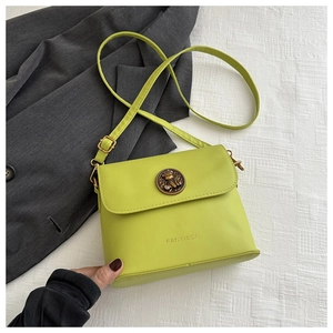 Detail of neon green leather bag with bronze vintage clasp and brand logo embossment