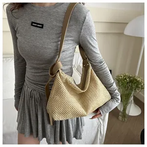 Detail of hand-woven straw shoulder bag with brown leather strap and tight beige texture